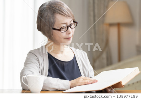 在客廳讀書的高級婦女 在客廳讀書的高級婦女 138977189