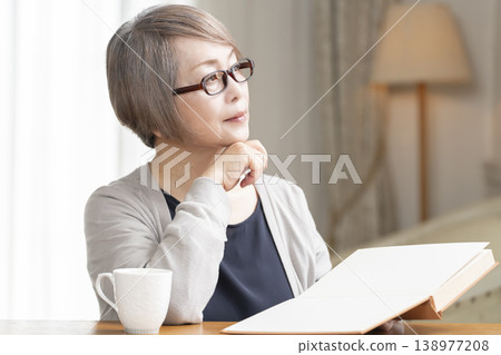 在客廳讀書的高級婦女 在客廳讀書的高級婦女 138977208