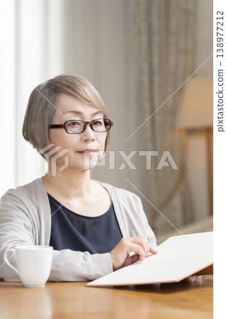 在客廳讀書的高級婦女 在客廳讀書的高級婦女 138977212