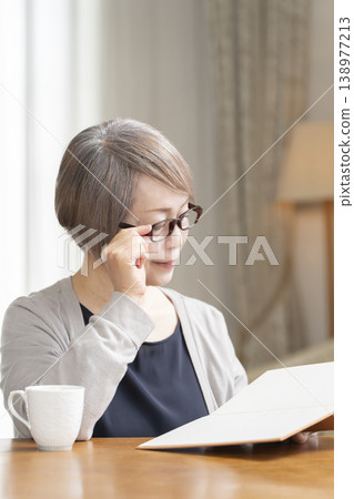 Senior woman reading in the living room Senior woman reading in the living room 138977213