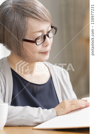 Senior woman reading in the living room Senior woman reading in the living room 138977231