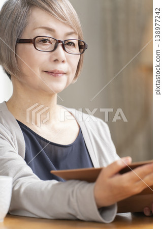 Senior woman reading in the living room Senior woman reading in the living room 138977242