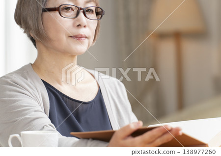Senior woman reading in the living room Senior woman reading in the living room 138977260