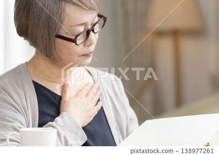 Senior woman reading in the living room 138977261