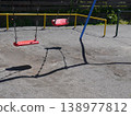 The shadow of a swing swaying in the afternoon park 138977812