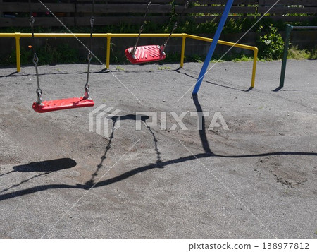 The shadow of a swing swaying in the afternoon park The shadow of a swing swaying in the afternoon park 138977812