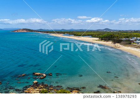 Aerial view of Rose Bay in Bowen, Queensland, Australia. The scene shows a tropical coastal landscape with clear blue water, sandy shoreline and surrounding natural environment. Aerial view of Rose Bay in Bowen, Queensland, Australia. The scene shows a tropical coastal landscape with clear blue water, sandy shoreline and surrounding natural environment. 138978293