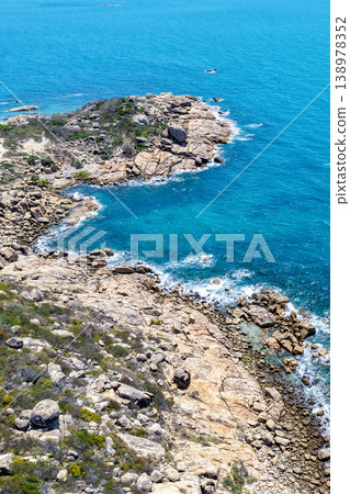 Aerial view of Rose Bay in Bowen, Queensland, Australia. The scene shows a tropical coastal landscape with clear blue water, sandy shoreline and surrounding natural environment. Aerial view of Rose Bay in Bowen, Queensland, Australia. The scene shows a tropical coastal landscape with clear blue water, sandy shoreline and surrounding natural environment. 138978352