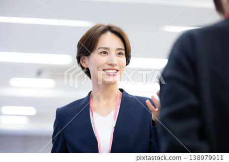 一位女士在商務場合與同事交談。 138979911