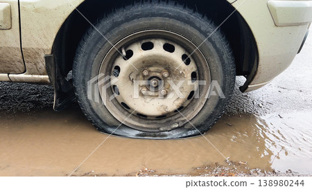 Flat tire on a car by the roadside. Flat tire on a car by the roadside. 138980244