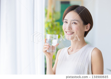Beauty image: A woman drinking water by the window 138980685