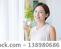 美麗的畫面：一位女子在窗邊喝水。 138980686