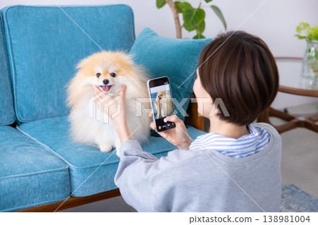 生活方式:一位女士用智慧型手機為她的狗拍照。 生活方式:一位女士用智慧型手機為她的狗拍照。 138981004