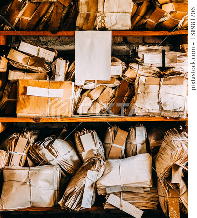 Shelves packed with bundles of old yellowed paper documents Shelves packed with bundles of old yellowed paper documents 138981206