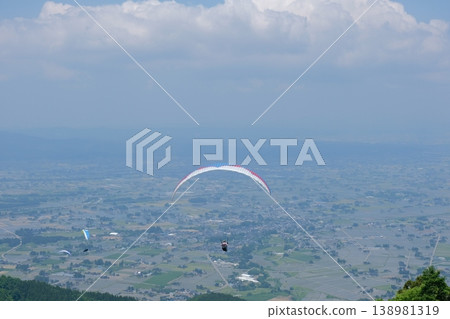 乘坐滑翔傘俯瞰散落著美麗村莊的風景——從空中俯瞰日本鄉村。 乘坐滑翔傘俯瞰散落著美麗村莊的風景——從空中俯瞰日本鄉村。 138981319