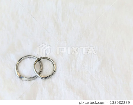 A pair of wedding rings placed against a white background. A simple image of a married couple. Copy space available. A pair of wedding rings placed against a white background. A simple image of a married couple. Copy space available. 138982289
