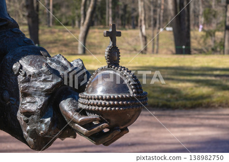 Bronze hand cradles ancient globe with beaded rim and cross atop 138982750