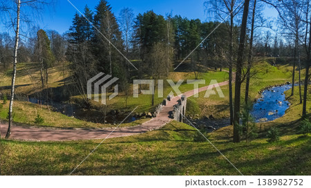 An old picturesque stone bridge in the landscaped spring park of Oranienbaum. 138982752