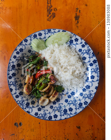 Thai Basil Squid Stir Fry with White Rice and Cucumber on Floral Plate Thai Basil Squid Stir Fry with White Rice and Cucumber on Floral Plate 138983088