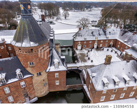 Aerial close-up of Anholt Castle, Wasserburg Anholt, in winter. The historic brick towers, snowy courtyard, and stone bridges over the frozen moat create a stunning medieval scene in Germany. Aerial close-up of Anholt Castle, Wasserburg Anholt, in winter. The historic brick towers, snowy courtyard, and stone bridges over the frozen moat create a stunning medieval scene in Germany. 138984558