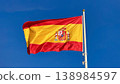 Spanish Flag Waving on Flagpole Against Clear Blue Sky, National Symbol of Spain 138984597