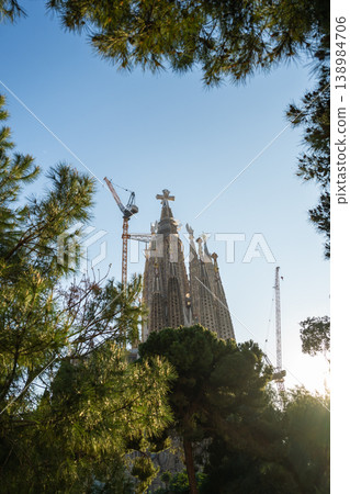 Sagrada Familia towers with construction crane and trees under blue sky in Barcelona Spain Sagrada Familia towers with construction crane and trees under blue sky in Barcelona Spain 138984706