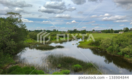 Rural landscape with a calm river and lush trees in the countryside Rural landscape with a calm river and lush trees in the countryside 138984844