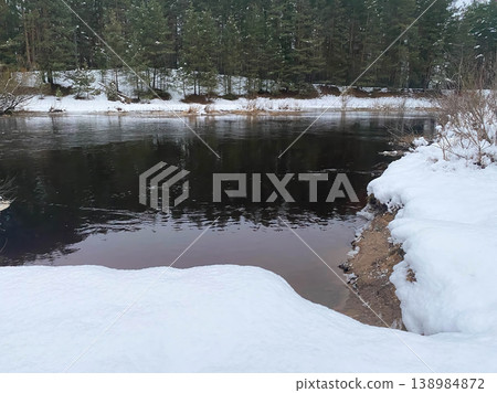 Winter river landscape with snowy banks and pine forest Winter river landscape with snowy banks and pine forest 138984872