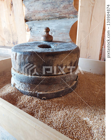 Ancient stone millstones for grinding wheat grain in a wooden barn 138984874
