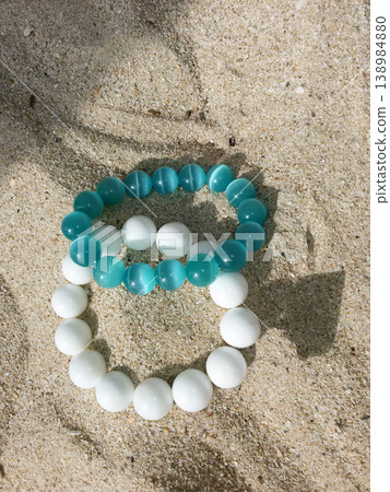 Top view of stylish summer accessories lying on a sandy beach texture Top view of stylish summer accessories lying on a sandy beach texture 138984880