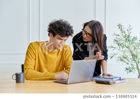 Confident female mentor teacher advising teaching male university student Confident female mentor teacher advising teaching male university student 138985324
