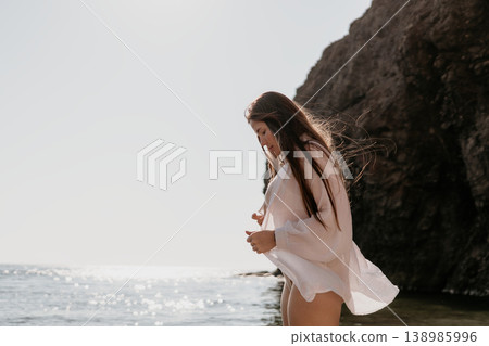 Woman beach breeze blowing through long hair and white blouse while standing by the ocean with copy space Woman beach breeze blowing through long hair and white blouse while standing by the ocean with copy space 138985996