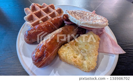 A British breakfast featuring sausages and waffles. A British breakfast featuring sausages and waffles. 138986702