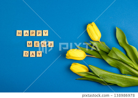 Happy Mens Day Background. Yellow tulips on blue color. Three flowers Happy Mens Day Background. Yellow tulips on blue color. Three flowers 138986978