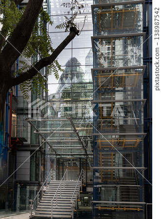 The high-tech Lloyd Register building, known for its 'inside-out' glass and steel design, features external elevators and a prominent canopied staircase. Its tiered facade captures ethereal The high-tech Lloyd Register building, known for its 'inside-out' glass and steel design, features external elevators and a prominent canopied staircase. Its tiered facade captures ethereal 138987542