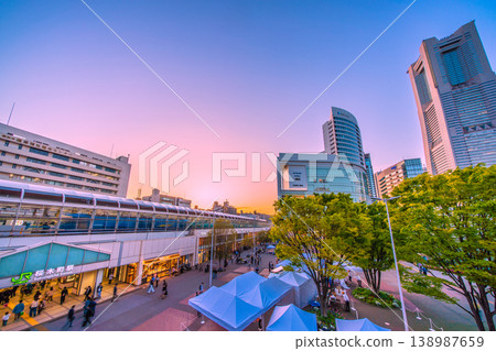Yokohama cityscape, Japan, April 18th. View of Sakuragicho Station, Yokohama Landmark Tower, and freight trains bathed in the setting sun. 138987659