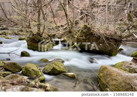 Water flows through the gaps in moss-covered boulders of the Oirase Stream. 138988148