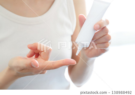 A woman's hands squeezing cream from a tube onto her fingertips. (Beauty) A woman's hands squeezing cream from a tube onto her fingertips. (Beauty) 138988492