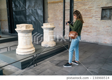 Young Woman Viewing Ancient Stone Columns in Museum Courtyard Cultural Exploration Scene 138988514