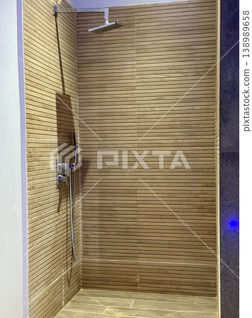 Wooden sauna interior with metal shower head and tiled walls, suitable for relaxation background Wooden sauna interior with metal shower head and tiled walls, suitable for relaxation background 138989658