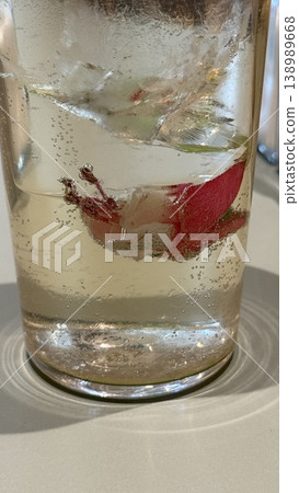 Glass with fizzy carbonated drink and fresh red chili pepper in transparent liquid background 138989668