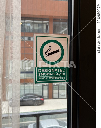 Designated smoking area sign on glass window with urban background view Designated smoking area sign on glass window with urban background view 138989679