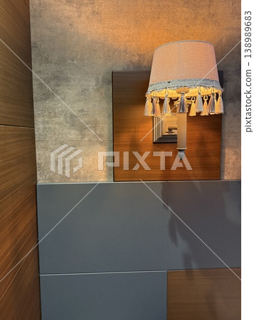 Wall lamp casting soft light on modern wooden and grey panels, suitable for background use 138989683