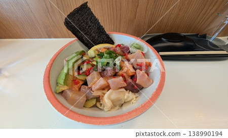 Poke bowl of tuna, salmon, sea bass, cucumber, scallion, and avocado 138990194