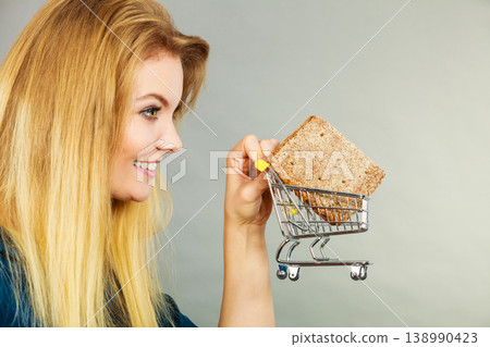 Woman holding shopping cart with bread 138990423