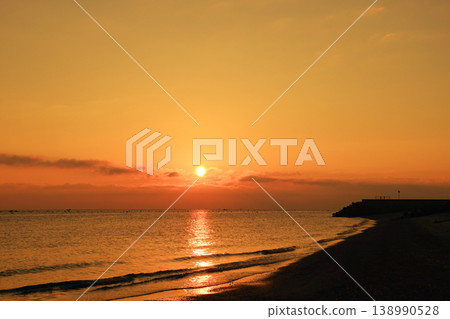 The sea, the sunrise, and the sky painted orange. The sea, the sunrise, and the sky painted orange. 138990528