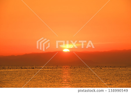 The sea, the sunrise, and the sky painted orange. The sea, the sunrise, and the sky painted orange. 138990549