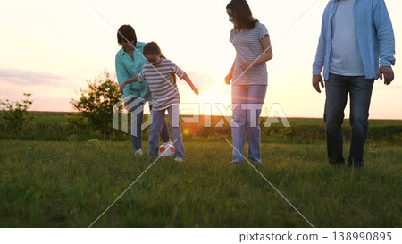 Happy family, child mother father playing soccer ball sun, people running green lawn football, kicking ball, fun game, developing motor skills, simple joyful moments, healthy active lifestyle Happy family, child mother father playing soccer ball sun, people running green lawn football, kicking ball, fun game, developing motor skills, simple joyful moments, healthy active lifestyle 138990895