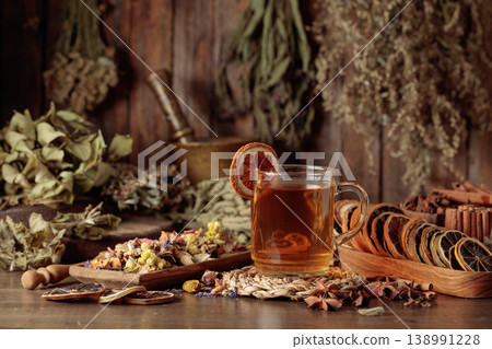 Cup of herbal tea with various dried herbs, flowers, and spices. 138991228