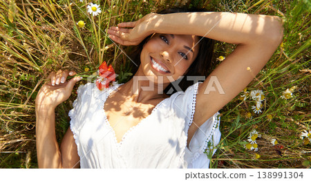 Portrait, top view and woman in grass with flower in the countryside in summer, vacation and relax. Face, happy person in field above and floral plant at farm in nature, garden or outdoor in Brazil 138991304